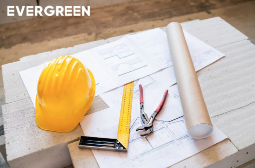 Construction plans and safety helmet on a desk, representing porta cabin air conditioning planning and site preparation.
